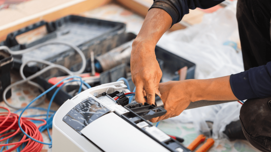 An HVAC technician adjusts wiring to repair a furnace.