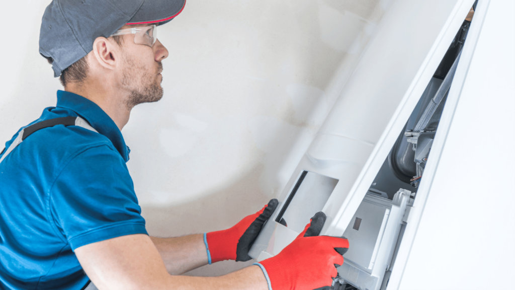 An HVAC technician places the outer panel on a newly installed furnace.