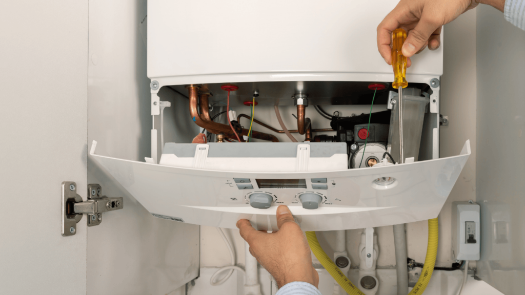 An HVAC technician uses a screwdriver to replace a heater.