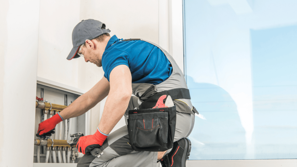 An HVAC technician works on a residential heating system.