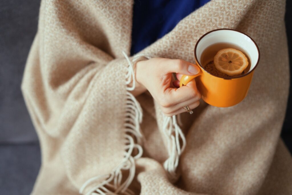 Woman hand holding cup of tea with lemon